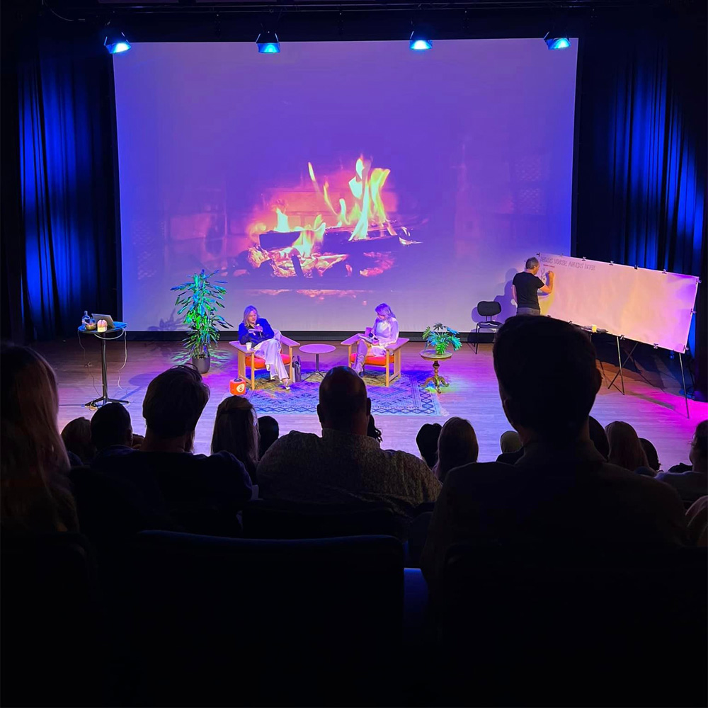 Graphic recorder aan het werk op podium voor publiek