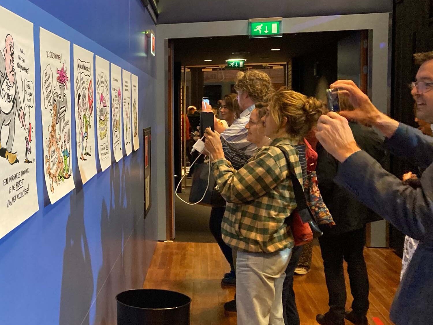 Bezoekers congres fotograferen tekeningen van live tekenaar