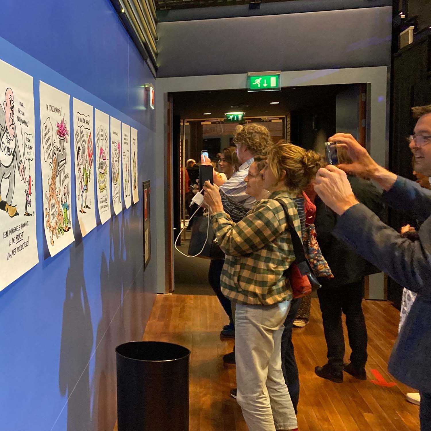 Bezoekers congres fotograferen tekeningen van live tekenaar