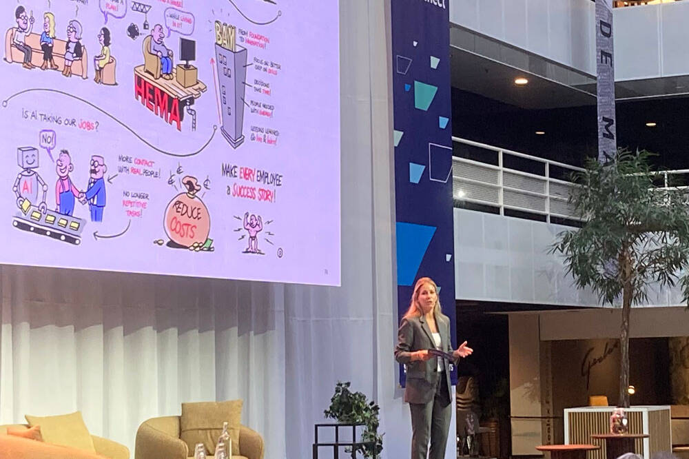Vrouw presenteert op podium digitaal live tekenen op groot scherm